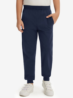 Model wearing navy fleece stretch water resistant boys joggers, front view showing lower body and pants.