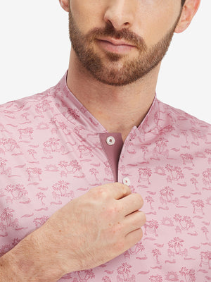 Close-up: nose to chest in pink beach palm stretch printed collarless henley golf shirts