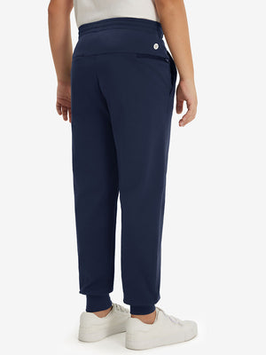 Model's lower body from the back, wearing navy fleece stretch water resistant boys joggers.