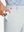 Close-up detail showing phone being placed in the pocket of light gray thermal water repellent fleece dress pants