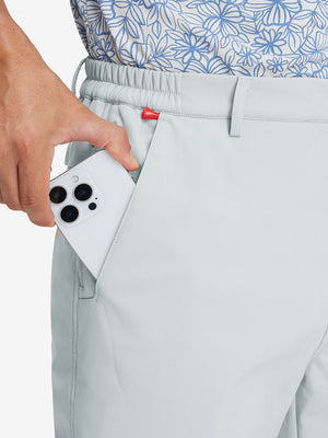 Close-up detail showing phone being placed in the pocket of light gray thermal water repellent fleece dress pants
