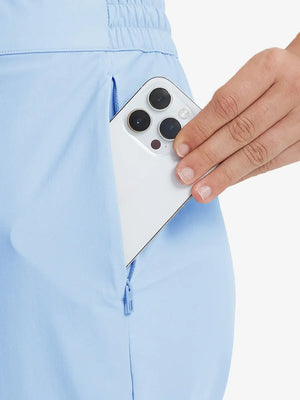 Detail shot of front side pocket holding an iPhone in LIGHT BLUE Women's 7/8 Ankle Golf Track Pants.