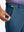 Hand placing a golf ball into pocket of water-resistant golf stretch nylon pants in blue indigo.