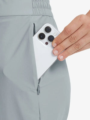 Detail shot of front side pocket holding an iPhone in LIGHT GREY Women's 7/8 Ankle Golf Track Pants.