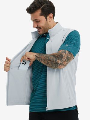 Close-up of water-resistant fleece golf vests pocket holding a phone, practical detail in misty grey