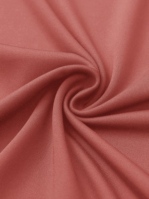 Close-up of coral pink women's performance solid polo fabric texture.