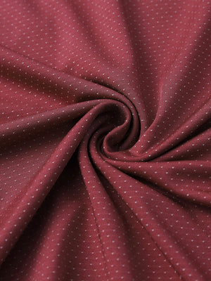 Close-up of wine 4 way stretch jacquard polo fabric texture highlighting intricate woven pattern and elasticity.