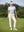 Woman wearing Women's Ultra-stretch Quick Dry Sweatpants with Ankle Zips in cream, holding golf club on course