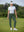 Woman wearing Women's Ultra-stretch Quick Dry Sweatpants with Ankle Zips in forest green, holding golf club on course