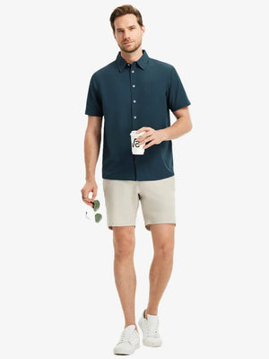 Detail shot with model holding a takeaway drink and sunglasses, featuring the BLUE INDIGO polo’s side vent.